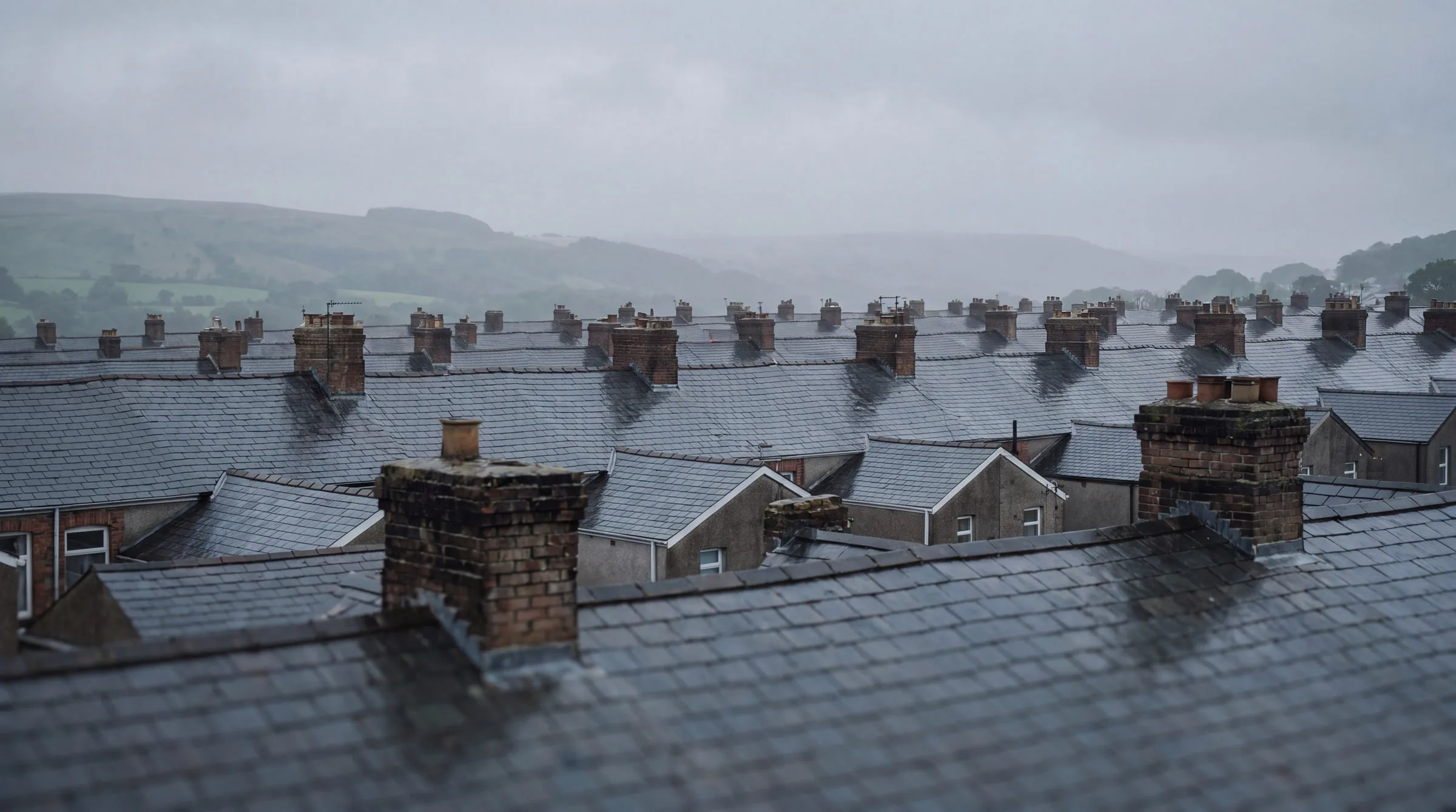 Slate rooftops and chimney stacks across a Welsh terraced street