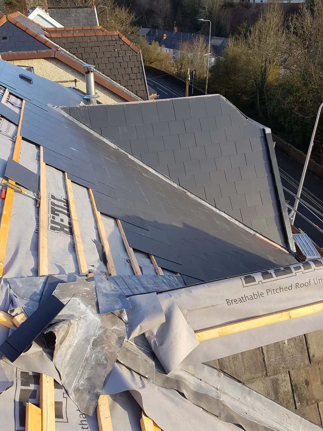 Slates being cut into a lead valley beside a slated dormer